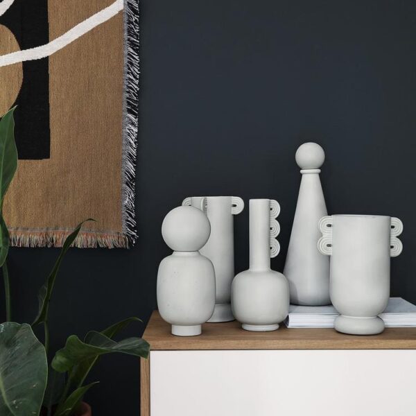 Collection of white modern ceramic vases on a cabinet.