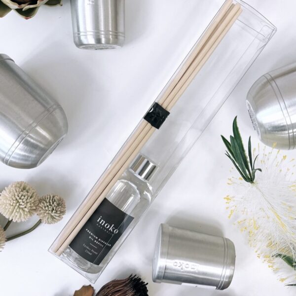 Silver candle holders and diffuser oil displayed with dried flowers