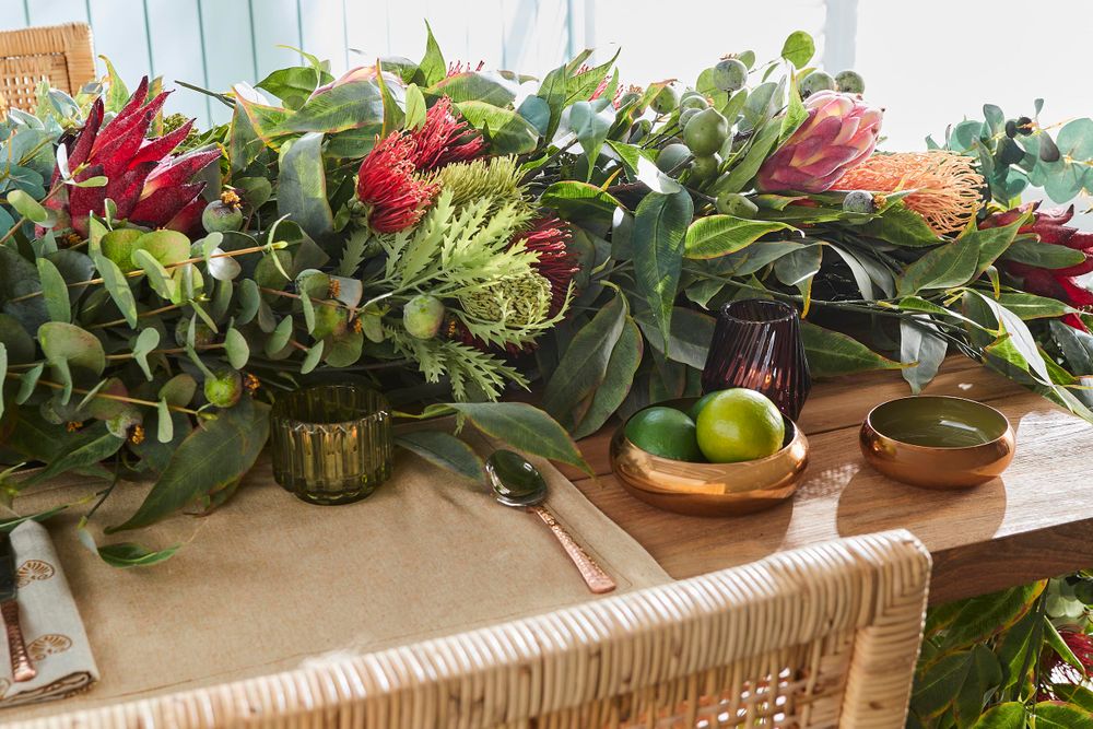 Table setting with vibrant floral centerpiece, bowls, and limes