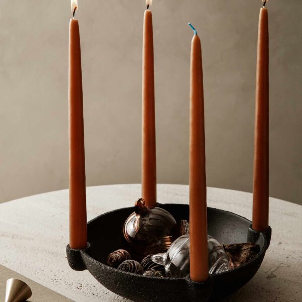 Black bowl with orange taper candles