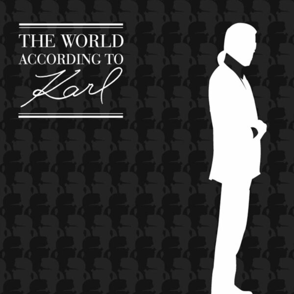 a man in a tuxedo standing in front of a black background