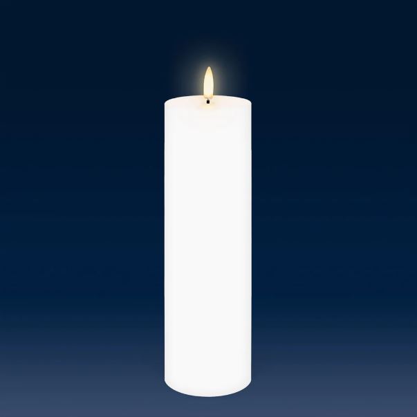 a white candle is lit against a dark background