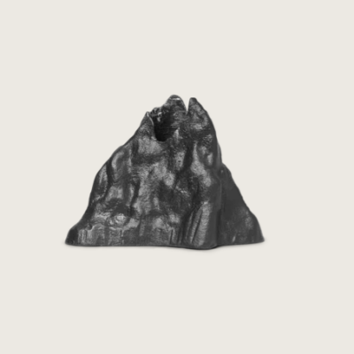 Small decorative black mountain-shaped object against a light background