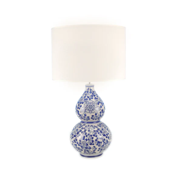 a blue and white table lamp with a white shade