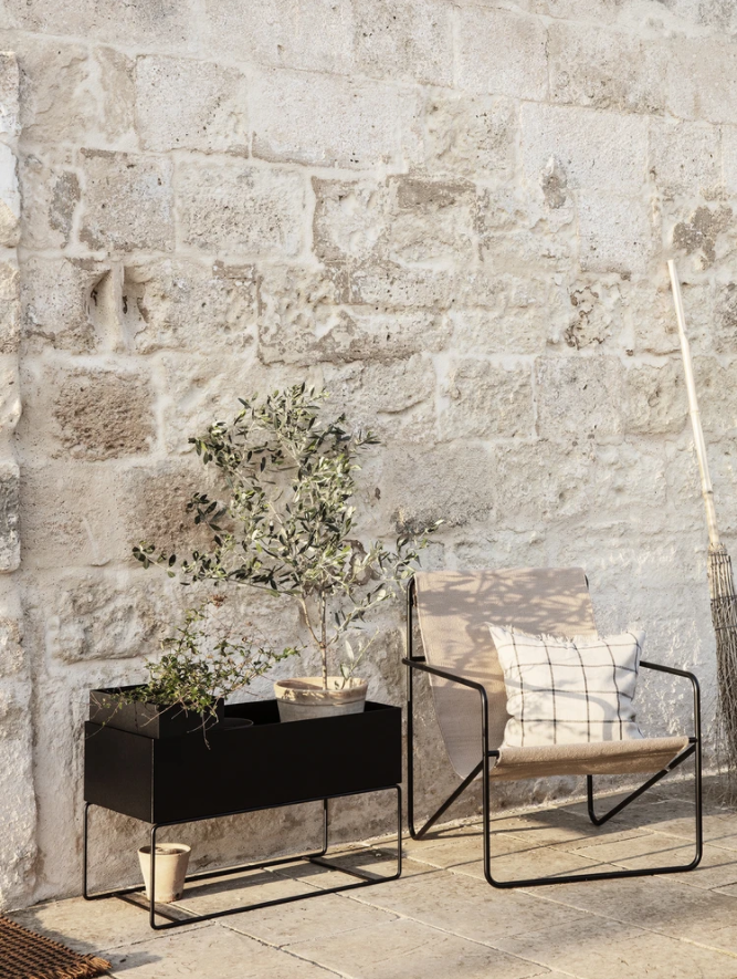 a planter with a tree in it next to a bench