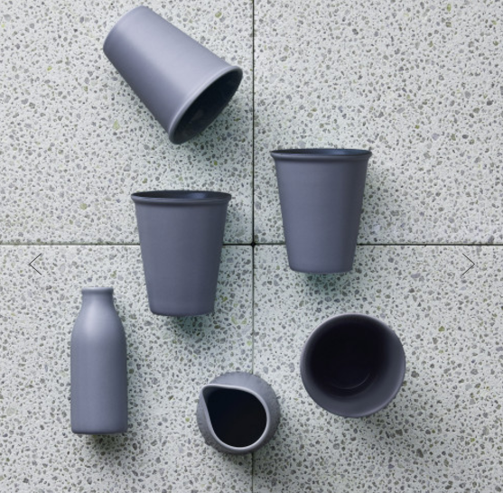 a group of grey cups sitting on top of a tiled floor