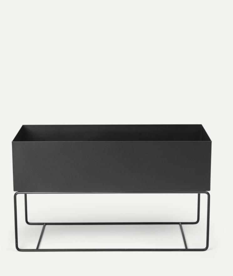 a black planter sitting on top of a metal stand