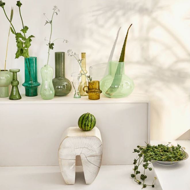 a white table topped with lots of green vases