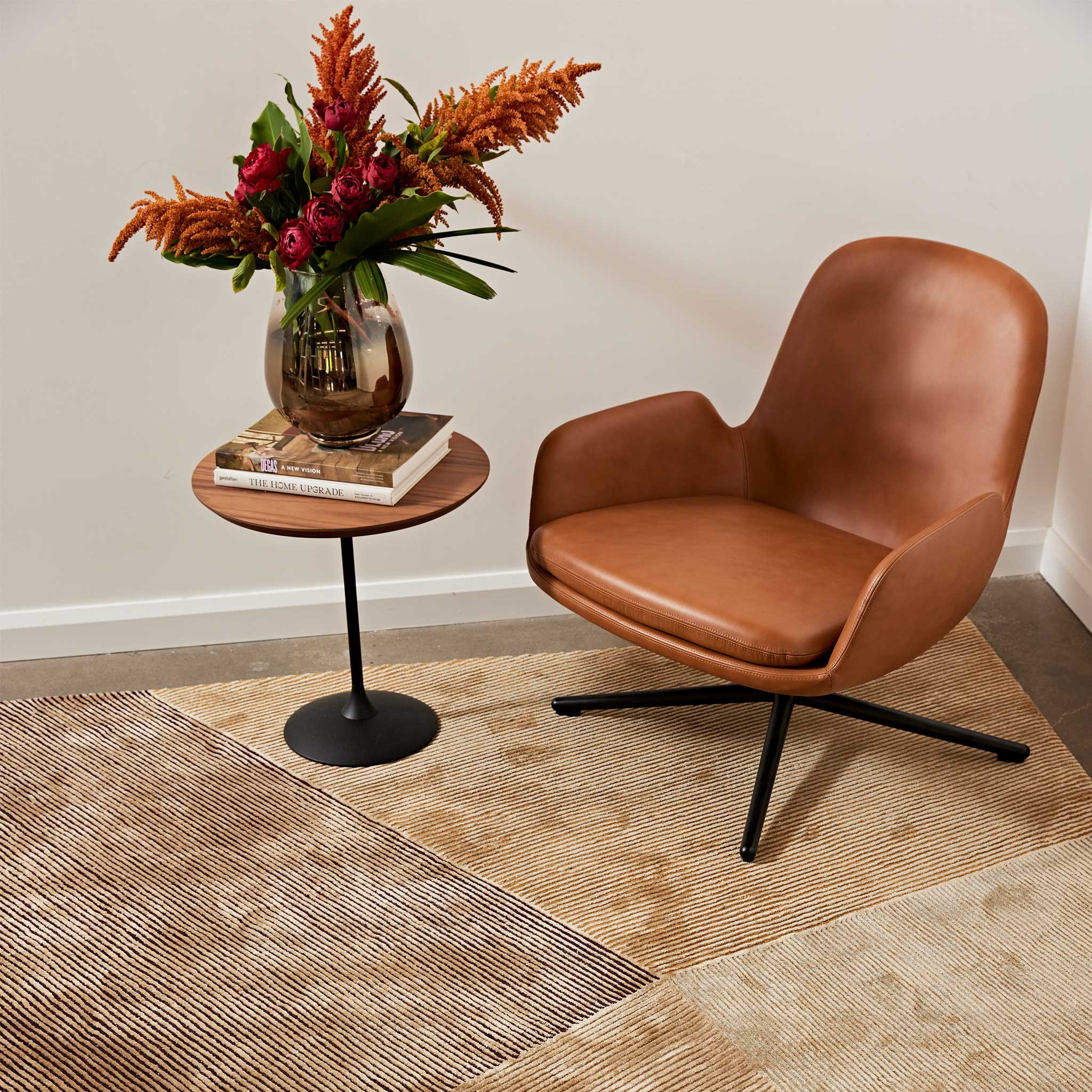 a chair and a table with a vase of flowers on it