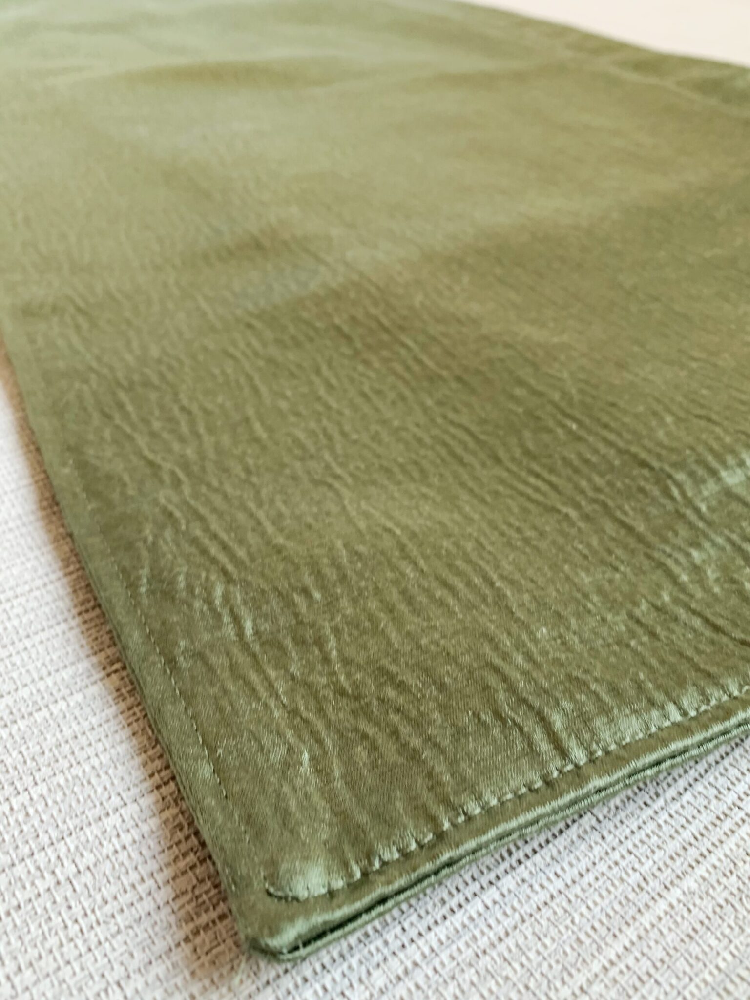 a close up of a green blanket on a bed
