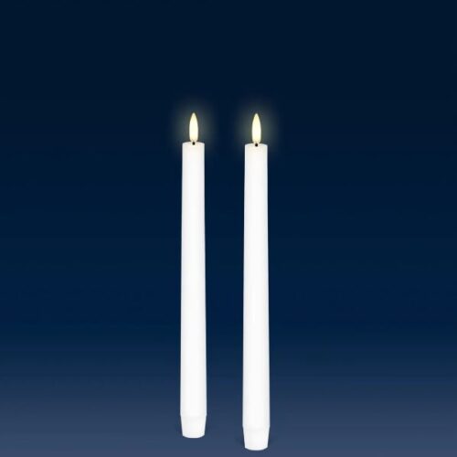two white candles sitting next to each other