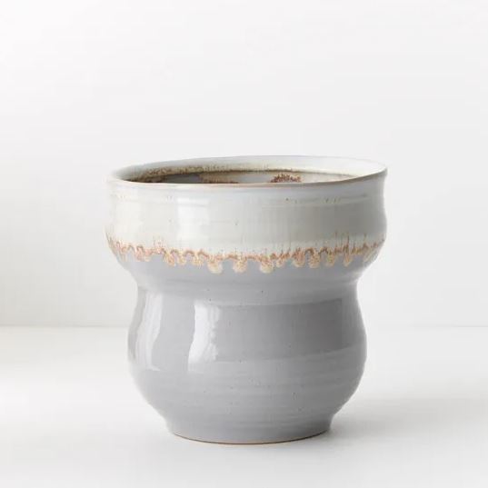 a gray and white cup sitting on top of a table