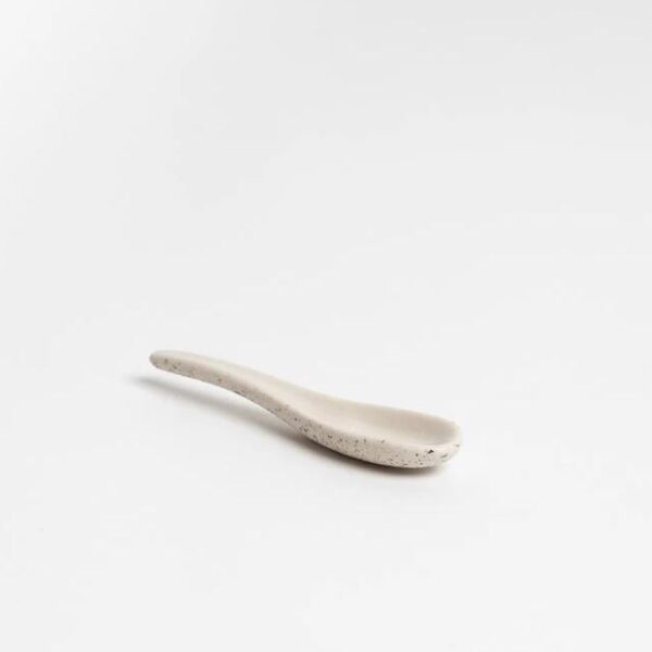 a white spoon sitting on top of a white table