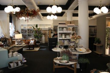 Interior of a well-decorated showroom featuring modern lighting, elegant furniture, and various home decor items on display, with a focus on stylish and sophisticated design elements.