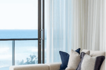 Elegant living room in Newcastle featuring custom curtains and blinds, styled with soft textures, natural light, and a calming neutral palette