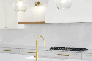 White kitchen with pale stone benchtops, timber stools, and brass accents – classic kitchen colour scheme idea.