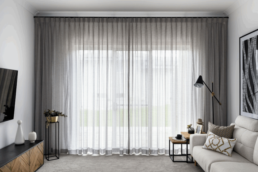 Layered curtains with sheer and blockout fabrics for managing sunlight and heat