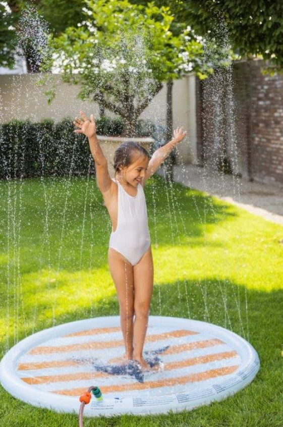 kids playing on shark sprinkler mat outdoors