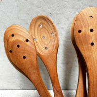 Cherrywood serving spoon with holes for draining, natural wood grain finish