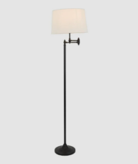 Matte black floor lamp Macleay base lit showing warm ambient glow in room setting