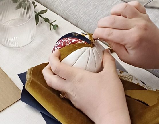Close-up of hands crafting a Christmas ornament during a holiday workshop.